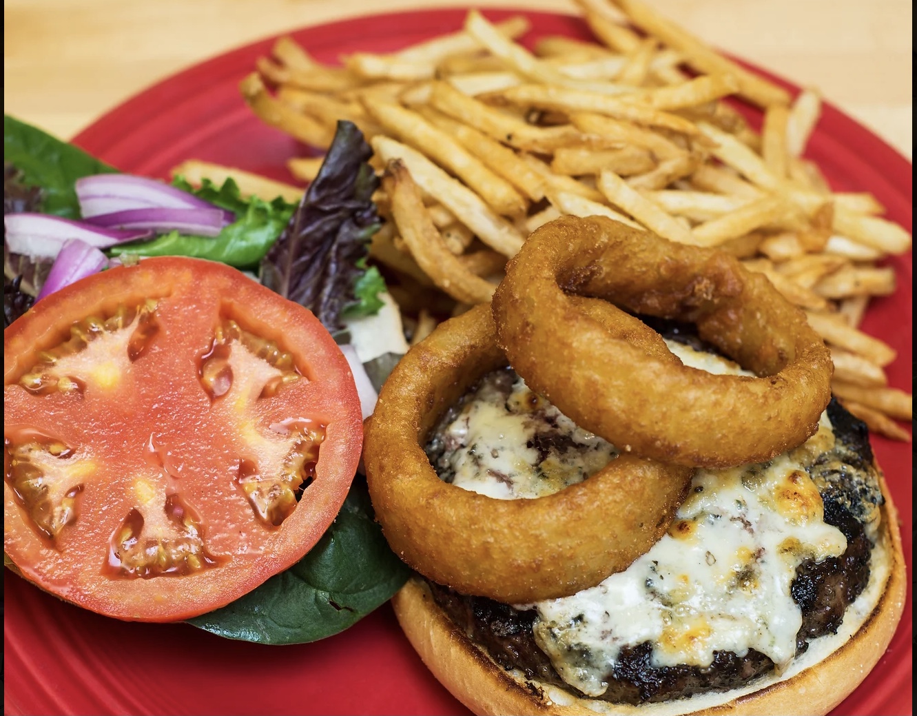 Chargrilled burger with onion rings and fries